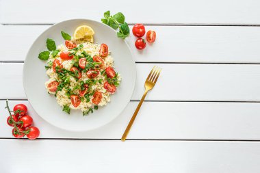 Taze ev yapımı tabouli, veya tabbouleh salatası, beyaz ahşap arka planda fotokopi alanı ile üst görünüm