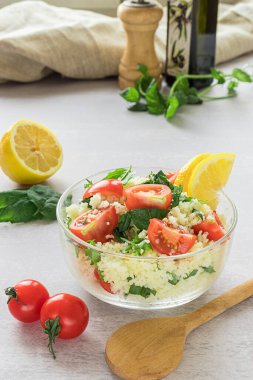 Taze ev yapımı tabouli, ya da tabbouleh salatası, içeriği gri arka planda.