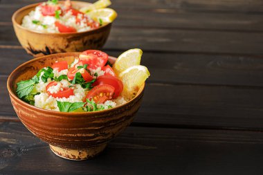 Taze ev yapımı tabouli, veya tabbouleh salatası, koyu ahşap arka planda yan görünüm, kopyalama alanı