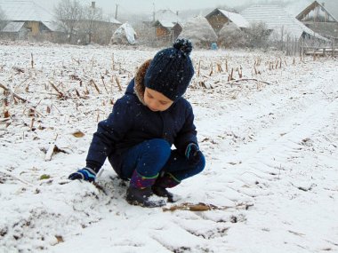 a little boy is playing in the snow