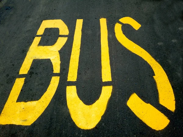 Ônibus Palavra Pintado Uma Estação Asfalto — Fotografia de Stock