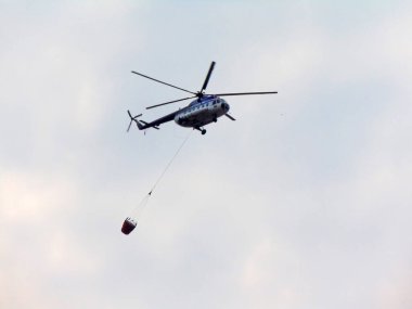 Bir helikopter yangını söndürmekten dönüyor.