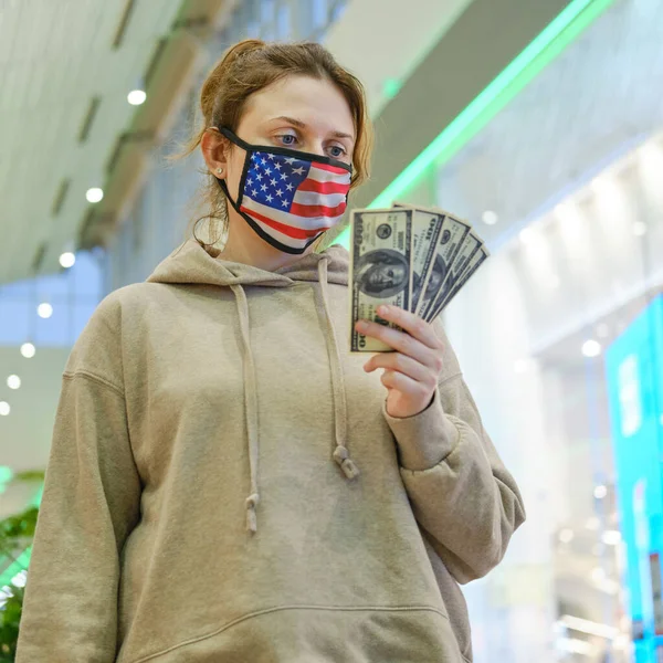 Adult woman with money on the street during the coronavirus pandemic