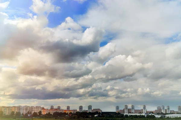 Cloudy sky and sun over the city. A lot of clouds are going to rain. Blue sky and clouds on a summer day.