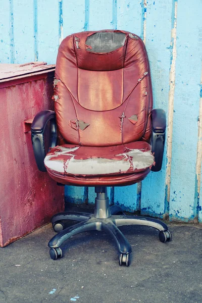 Old leather computer chair thrown into the street, bankrupt concept and business problems