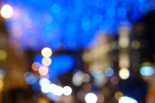 Blurred background of city street in bokeh of garlands and lanterns, new year celebration