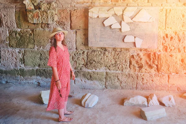 woman among the archaeological excavations in the dungeon Anthony terms, an ancient Roman building. Ruins of antique inscriptions in the Carthage times of the Punic wars with Rome.