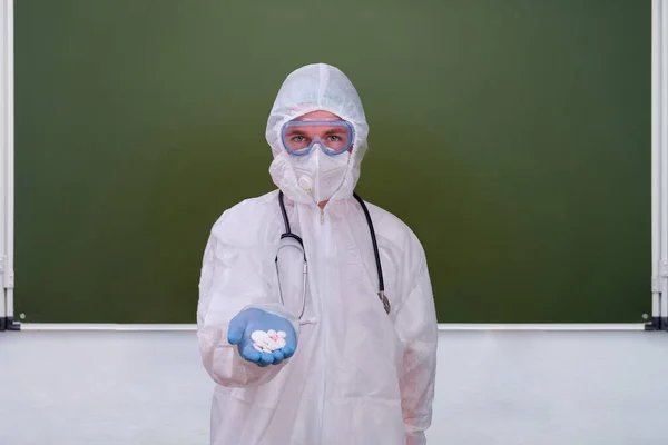 Sad teacher sits on the background of the blackboard, copy space