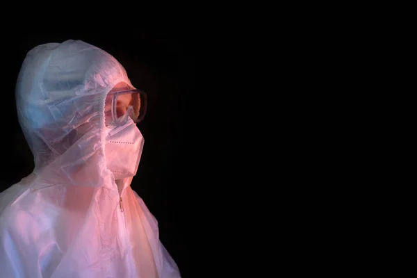 Doctor in a white medical suit with goggles, profile view