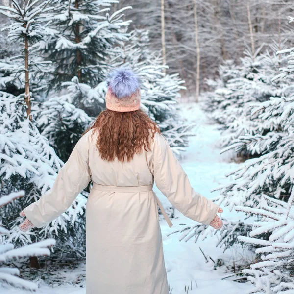 A woman chooses a Christmas tree in the nursery store in winter nature on New Year Eve