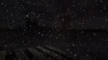 Sessiz, aydınlık bir şehir manzarasına, karanlık gece gökyüzünden düşen karlı sakin bir animasyon. Huzurlu kış havası, arka plan ambiyansı ya da bayram manzarası gerektiren projeler için mükemmel..