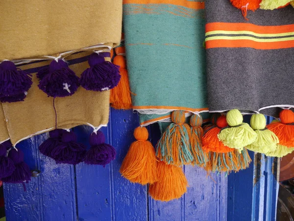 Close up of 3 hand-made Moroccan throws, blue background, Essaouira