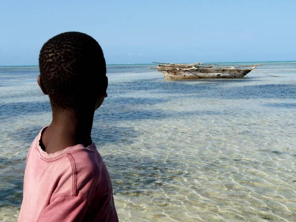 Afrikaanse adolescent kijkt uit op zee op ngalawa, Jambiani, Zanzibar — Stockfoto