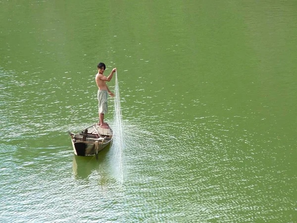 เด็กชายวัยรุ่นบนเรือพร้อมตาข่ายประมง เลคเลค ไฮแลนด์ เวียดนาม — ภาพถ่ายสต็อก