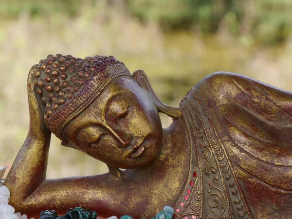 Primer plano del elegante Buda dorado reclinable con expresión serena —  Fotos de Stock