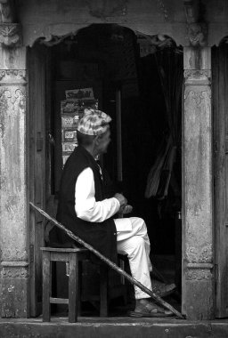 Geleneksel kıyafetler giyen ahşap kapı ağzındaki adam, Haydut, Nepal. Yüksek kalite fotoğraf