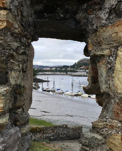 Attractive Vue des bateaux dans le port de Conwy encadrée par une fenêtre dans les rochers Pays de Galles — Photo