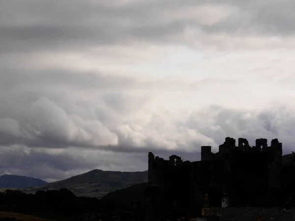 Vista lontana e buia del castello di Conwy, Galles, sagomato contro il cielo — Foto Stock