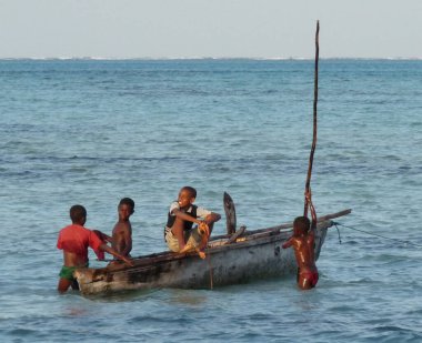 Sığ sularda teknede oynayan dört genç çocuk, Jambiani, Zanzibar