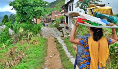 Bandipur, Nepal 'de kafasında tepsi olan genç bir kadının dikiz manzarası. Yüksek kalite fotoğraf