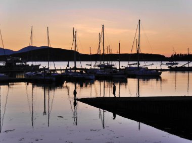 Baba ve çocuğun çarpıcı manzarası suya, günbatımına, Oban İskoçya 'sına yansıyor. Yüksek kalite fotoğraf