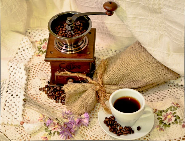 Coffee mill with burlap sack of roasted beans and white cup of coffee — Stock Photo, Image