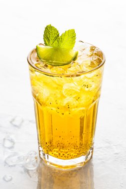 Beyaz arka planda buz küpleri olan bir bardak soğuk içecek.