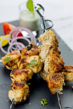 Nane soslu ya da acılı şişte servis edilen tavuk tikka kebabı.