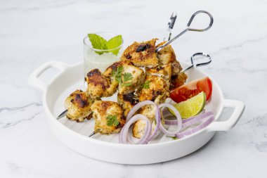 Nane soslu ya da acılı şişte servis edilen tavuk tikka kebabı.