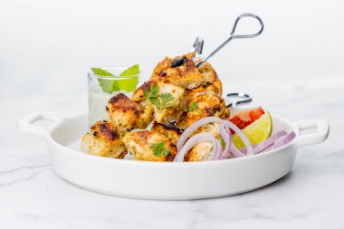 Nane soslu ya da acılı şişte servis edilen tavuk tikka kebabı.