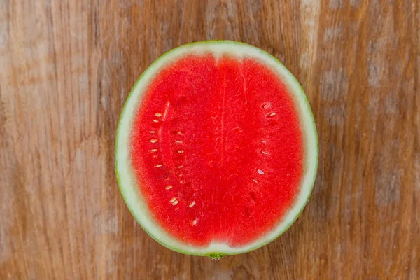 Wassermelone auf altem Holztisch halbiert — Stockfoto