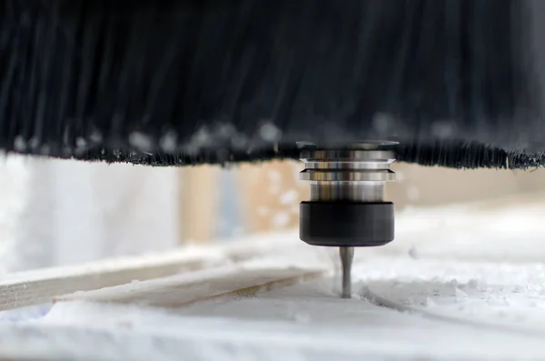 Gros plan - fraisage sur une machine CNC. Coupe les pièces bouclées de la feuille acrylique. Diffusion de la sciure dans différentes directions. — Photo