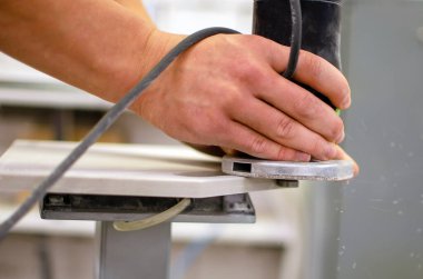 Bir marangoz ahşap bir tahtayı odunluyor. Kesici ve talaş.