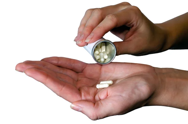 As pílulas medicinais são derramadas do frasco da pílula no braço. Probióticos. Conceito de medicina isolado em fundo branco — Fotografia de Stock
