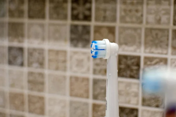 Rechargeable, electric toothbrush, close-up. Against the backdrop of a bathroom in white. — Stock Photo, Image