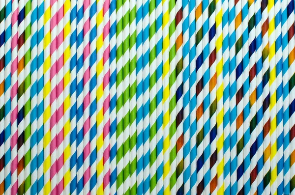 Saman kağıdı içmek. Çizgili içecek pipetlerinin arka planı farklı renklerde.