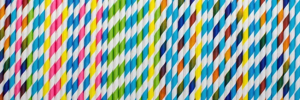 Saman kağıdı içmek. Çizgili içecek pipetlerinin arka planı farklı renklerde.