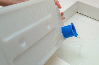 Kurutucudan çıkan konteynırda bir kadın kurutucudaki çamaşırları kuruttuktan sonra biriken suyu boşaltıyor..