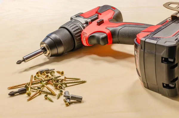 Red cordless drill on a black background. Screw tightening tool — Stock Photo, Image