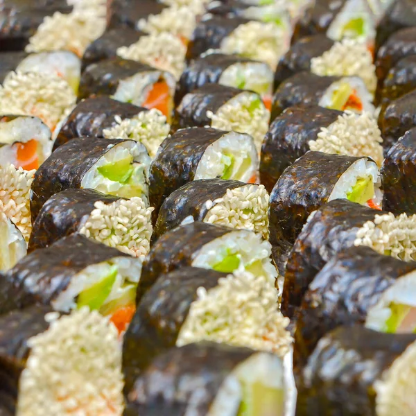 Świeże pyszne japońskie sushi z awokado, ogórek, krewetki, zbliżenie. — Zdjęcie stockowe