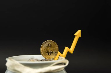 Kripto para birimi fiyatı. Kripto para biriminin dalgalanmaları ve tahminleri. Fiyat grafiğindeki bitcoin para yukarı işaret ediyor. Siyah arkaplanda, boşluğu kopyala