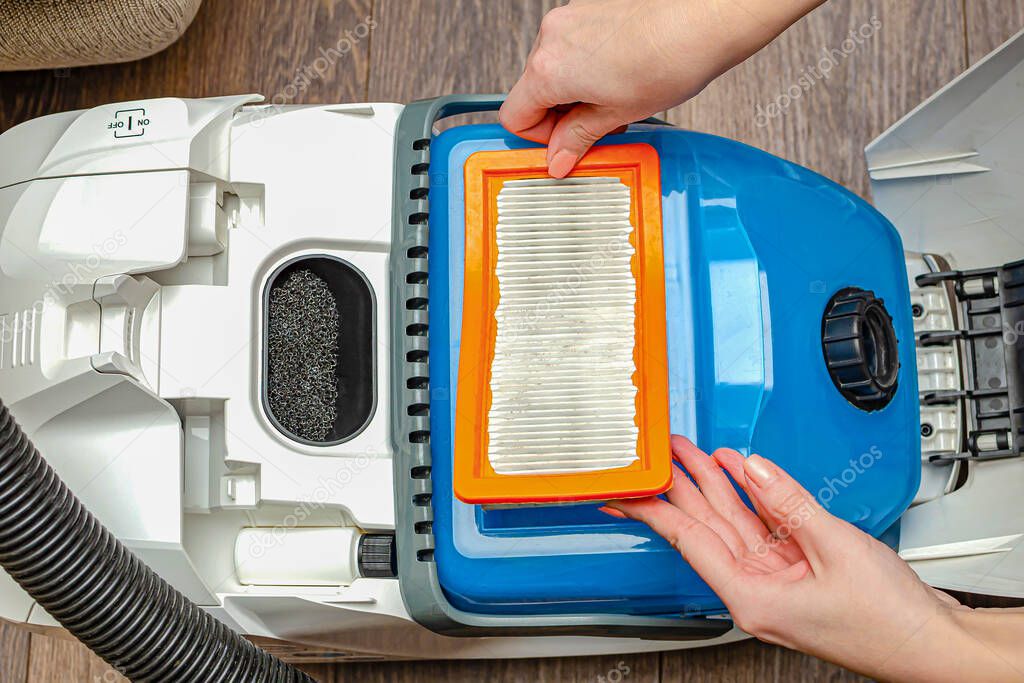 Manual replacement of the air filter in a modern washing vacuum cleaner. removes the filter of the vacuum cleaner by hand.