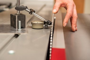 Saw disk çemberi kurulumu. Zanaatkar ahşap işçiliği makinesine dairesel testere bıçağı yerleştirir. Dairesel testere bakımı ve ayarlaması