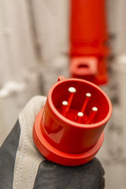 Elinde yüksek voltaj prizi var. 380 voltluk yüksek voltajı, üç faz prizini prize bağlıyorum..