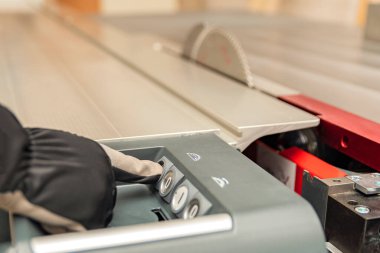 Endüstriyel makineyi çalıştıran düğmeye el basar. Testere kesme bıçağı. Endüstriyel makinelerin ve sanayideki bitki ekipmanlarının kontrolü için anahtarlar