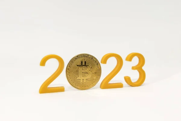 Predicción de precio de Bitcoin para 2023, valor de la criptomoneda en 2023. Números amarillos y moneda bitcoin sobre fondo blanco — Foto de Stock