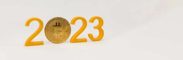 Predicción de precio de Bitcoin para 2023, valor de la criptomoneda en 2023. Números amarillos y moneda bitcoin sobre fondo blanco — Foto de Stock
