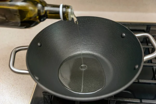 Cooking pilaf in a cauldron, a recipe for real pilaf. Grape seed oil for cooking pilaf, pour oil into a cauldron, a saucepan, before cooking. — Stock Photo, Image