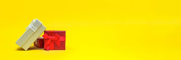 Κουτιά δώρων σε κίτρινο φόντο, πανό. Κόκκινο κουτί δώρου, ανοιχτό κουτί. Ταχυδρομική κάρτα για εκτύπωση, πανό με θέση για κείμενο. πανοραμικές φωτογραφίες, μεγάλου μεγέθους, άδειος χώρος για συγχαρητήρια ή σχεδιασμό — Φωτογραφία Αρχείου