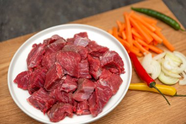 Kazanda pilav pişirmek, gerçek pilav tarifi. Ahşap arka planda pilav pişirmek için gerekli malzemeler. Tahta kesme tahtasının üzerinde soğan, biber, havuç, kıyma. Evde pilav pişirmek